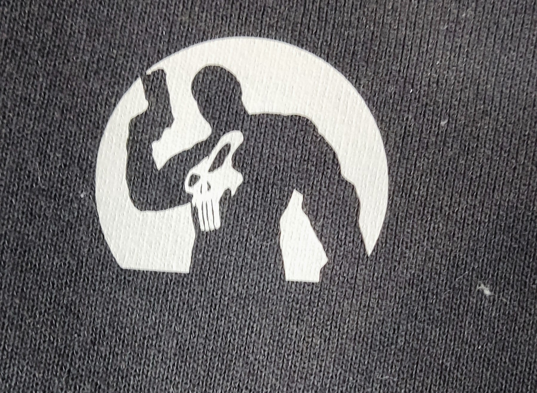 Escudo de vinilo situado en el pecho izquierdo con la silueta de Punisher 